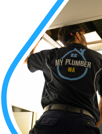A My Plumber WA technician in a branded navy polo shirt working on a ceiling access panel inside a home.